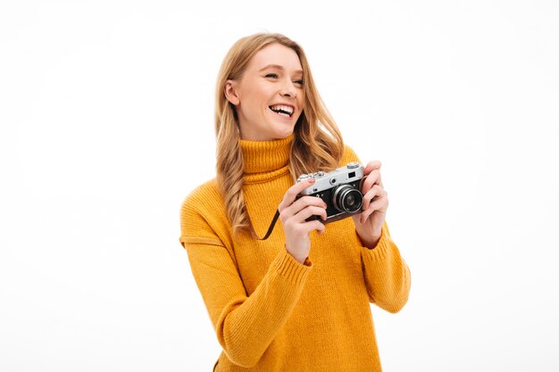 Macchina fotografica sveglia della tenuta della giovane donna.