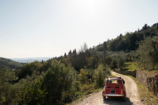 Macchina rossa su strada di campagna