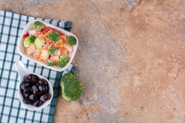 Macedonia di frutta e verdura in un piatto bianco con olive nere