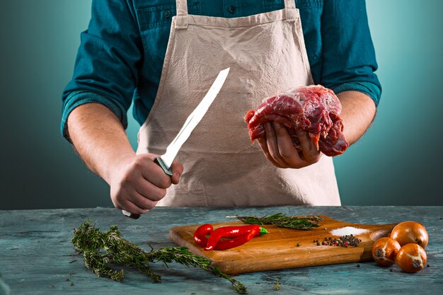 Macellaio che taglia la carne suina sulla cucina
