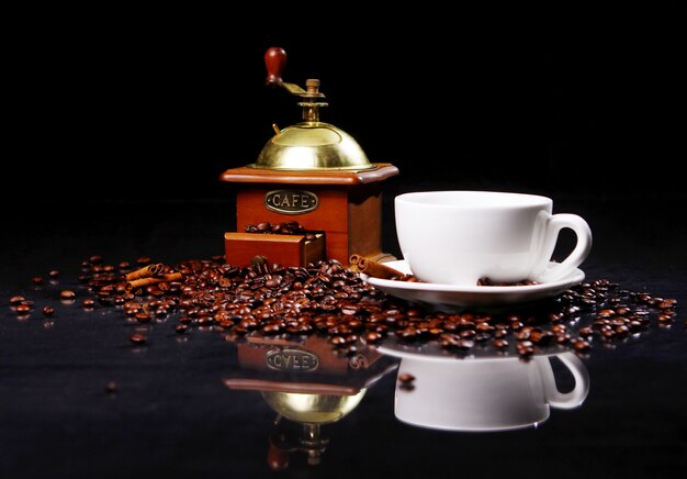 Macinacaffè sul tavolo con chicchi di caffè intorno