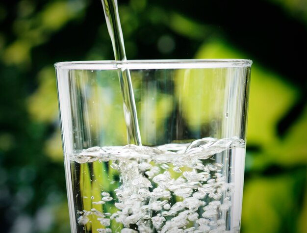 Macro colpo di versare acqua in un bicchiere