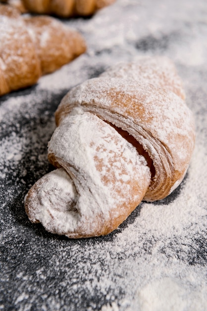 Macro immagine dei croissant con zucchero a velo sulla tavola grigia.