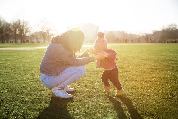 Madre a tutto campo che aiuta il bambino a camminare