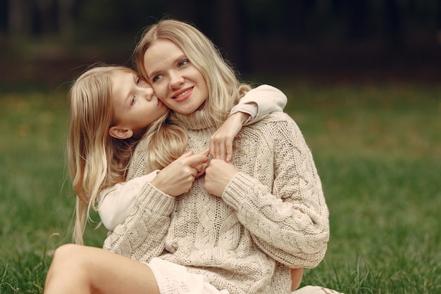 Madre alla moda con la figlia. La gente cammina fuori