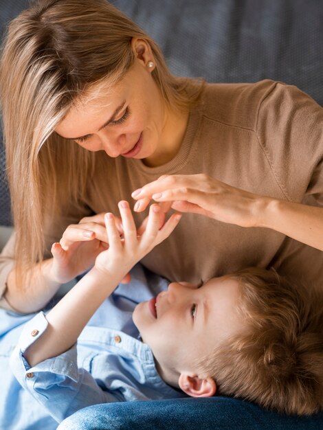 Madre bionda che gioca con il giovane figlio sveglio