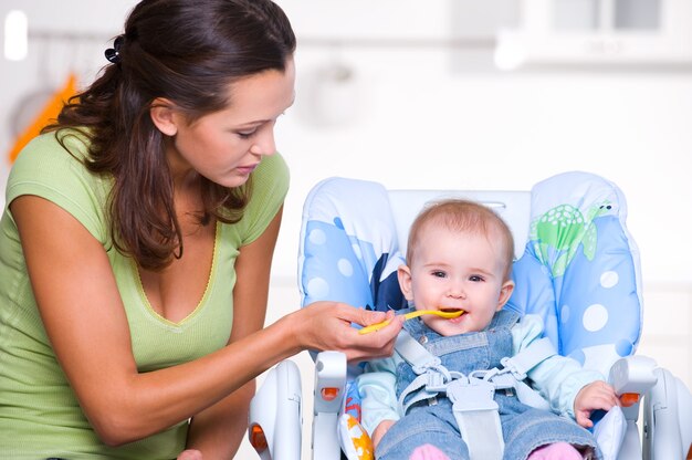 Madre che alimenta il bambino affamato