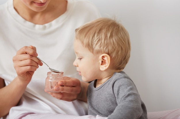 Madre che alimenta il suo piccolo figlio