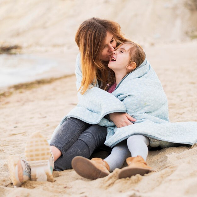 Madre che bacia figlia carina