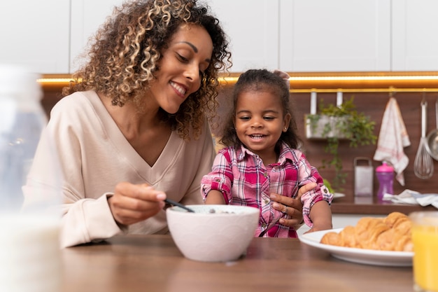 Madre che dà da mangiare a sua figlia in cucina