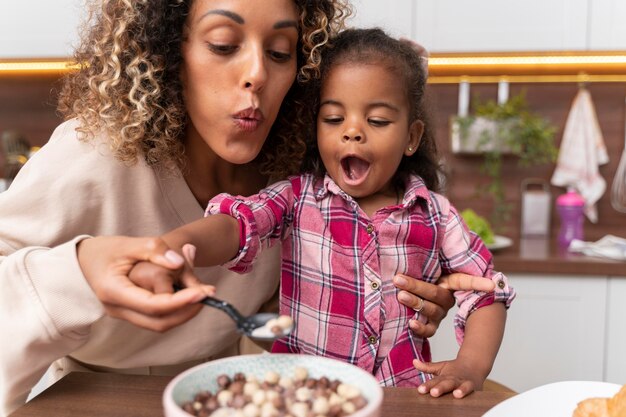 Madre che dà da mangiare a sua figlia in cucina