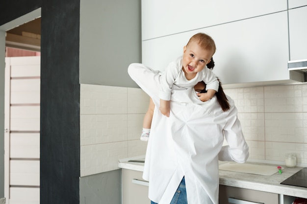 Madre che gioca con il bambino piccolo in cucina