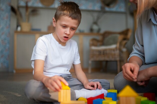 Madre che gioca con suo figlio autistico usando dei giocattoli