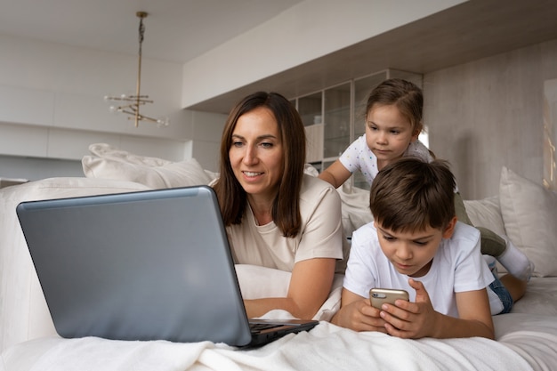 Madre che lavora in telelavoro da casa vista laterale