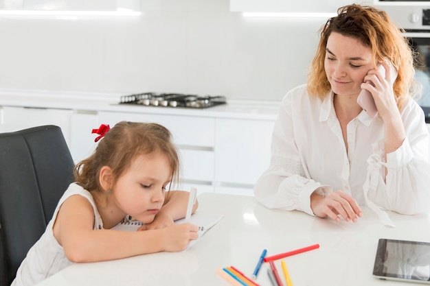 Madre che parla sul telefono a casa