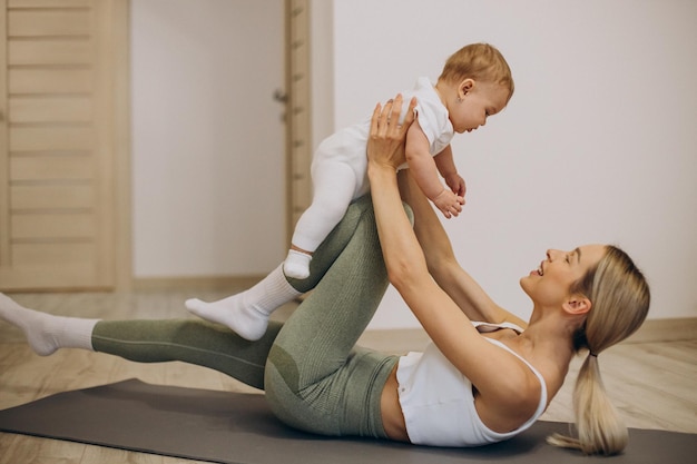 Madre che pratica yoga con la sua bambina a casa