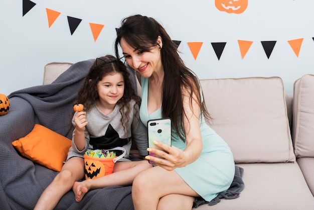 Madre che prende un selfie con la figlia su Halloween