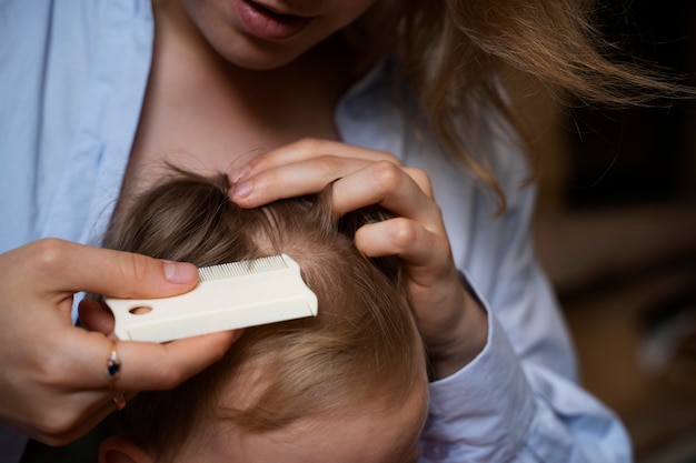 Madre che si prende cura di suo figlio con i pidocchi