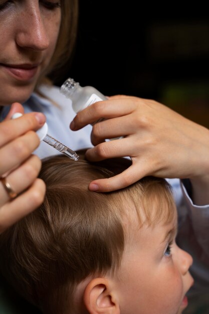 Madre che si prende cura di suo figlio con i pidocchi