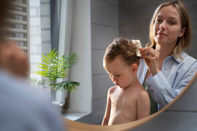 Madre che si prende cura di suo figlio con i pidocchi