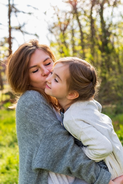 Madre che tiene vista laterale del bambino felice