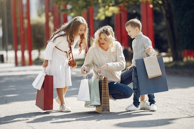 Madre con bambino con la borsa della spesa in una città