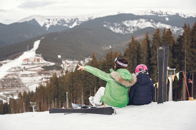 Madre con figlia a sciare. Persone nelle montagne innevate.