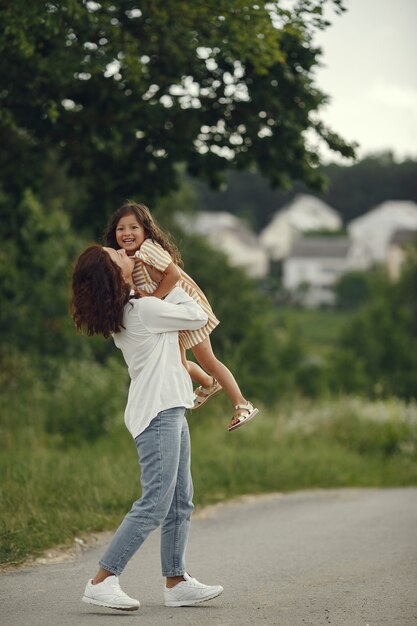 Madre con figlia che gioca in un campo estivo