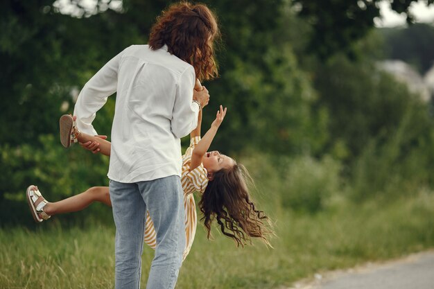 Madre con figlia che gioca in un campo estivo