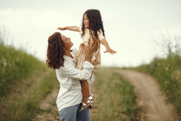 Madre con figlia che gioca in un campo estivo