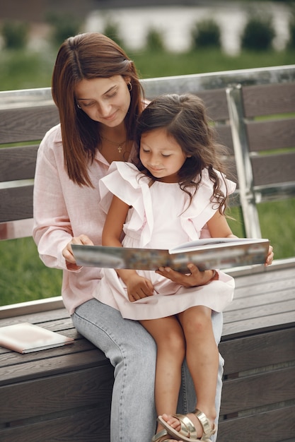 Madre con figlia che legge un libro in città