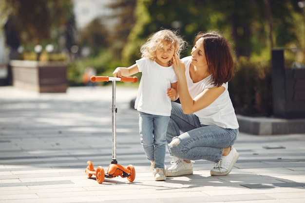 Madre con figlia in un parco di primavera con il pattino