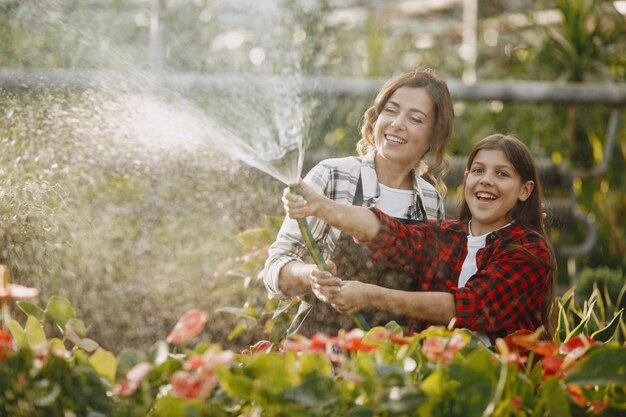 Madre con figlia. Lavoratori con fioriere. La gente versa fiori