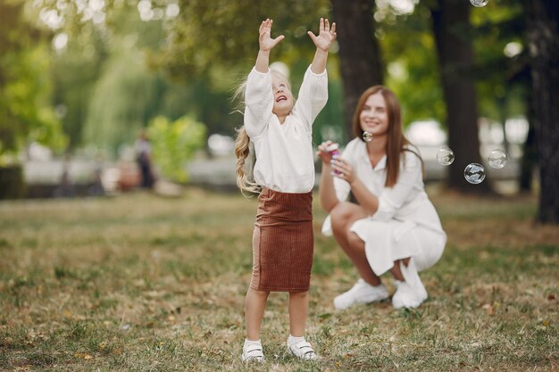 Madre con figlia piccola, giocando in un parco estivo