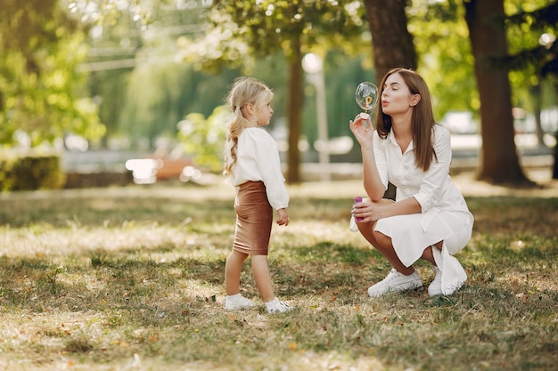 Madre con figlia piccola, giocando in un parco estivo