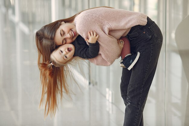 Madre con figlia piccola in piedi in una sala