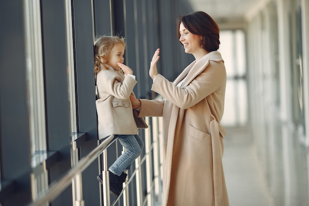 Madre con figlia piccola in piedi in una sala