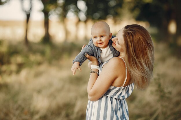 Madre con figlio piccolo, giocando in un campo in autunno