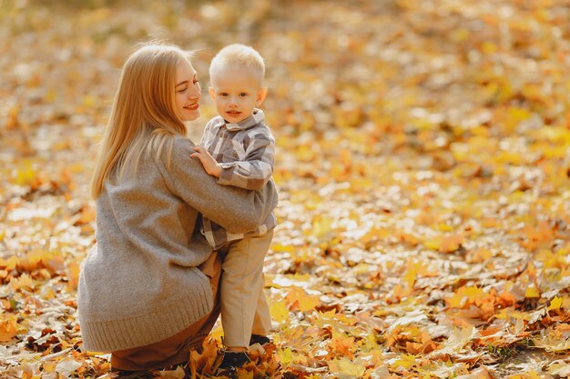 Madre con figlio piccolo, giocando in un campo in autunno