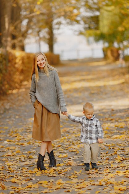 Madre con figlio piccolo, giocando in un campo in autunno