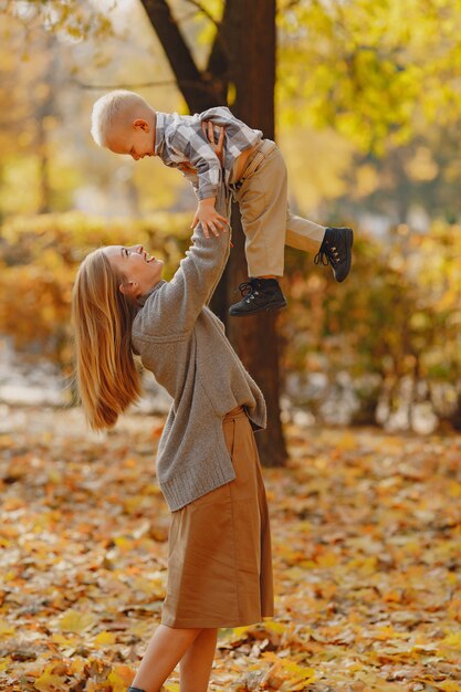 Madre con figlio piccolo, giocando in un campo in autunno