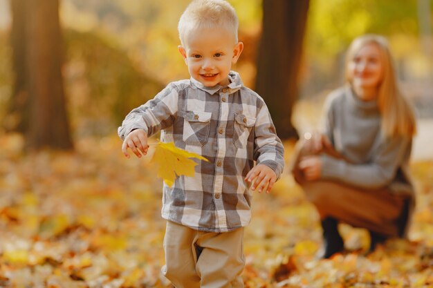 Madre con figlio piccolo, giocando in un campo in autunno