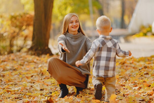 Madre con figlio piccolo, giocando in un campo in autunno