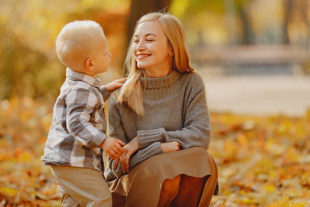 Madre con figlio piccolo, giocando in un campo in autunno