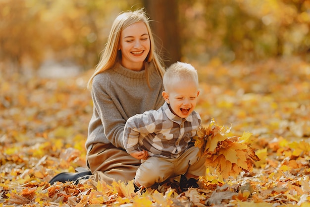 Madre con figlio piccolo, giocando in un campo in autunno