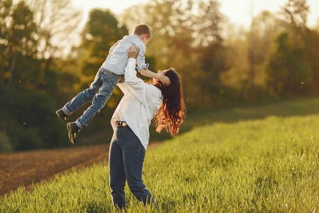 Madre con figlio piccolo, giocando in un campo in autunno