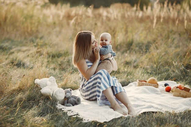 Madre con figlio piccolo seduto in un campo in autunno