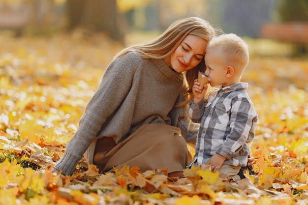 Madre con figlio piccolo seduto in un campo in autunno