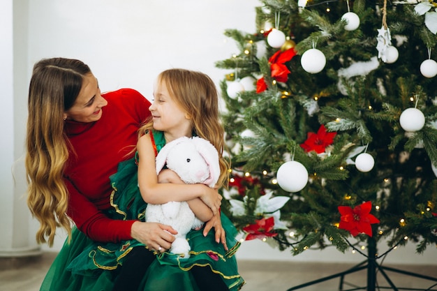 Madre con i regali dell&#39;imballaggio della figlia dall&#39;albero di Natale