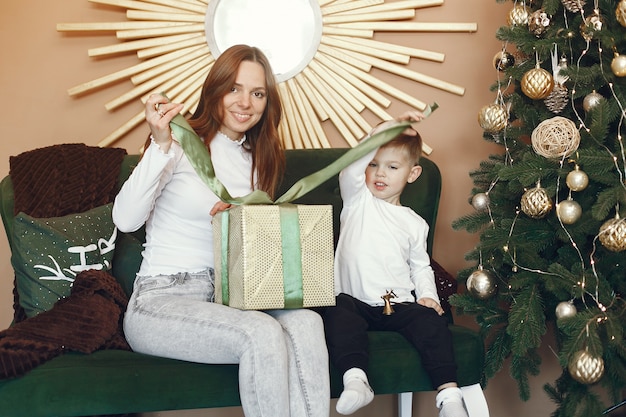 Madre con il figlio sveglio vicino all'albero di Natale